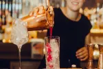 Barkeeper gießt einen Cocktail in ein Glas