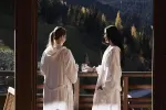 Zwei Frauen in Bademänteln genießen die Bergsicht.
