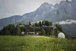 Landschaft mit Bergen und einem modernen Gebäude