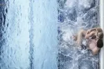 Junge schwimmt in einem Pool mit spritzendem Wasser