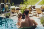 Paar im Wasser eines Pools, entspannend in der Sonne.