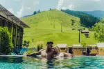 Paar entspannt im Pool mit Hügel im Hintergrund