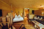 Holzschlafzimmer mit Bett, Sitzgelegenheiten und heller Dekoration