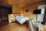 Modernes Holz-Hotelzimmer mit Bett und Sitzbereich