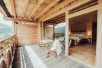 Holzbalkon mit Sitzgelegenheiten und Bergblick