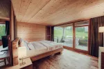 modernes Schlafzimmer mit Holzelementen und großen Fenstern
