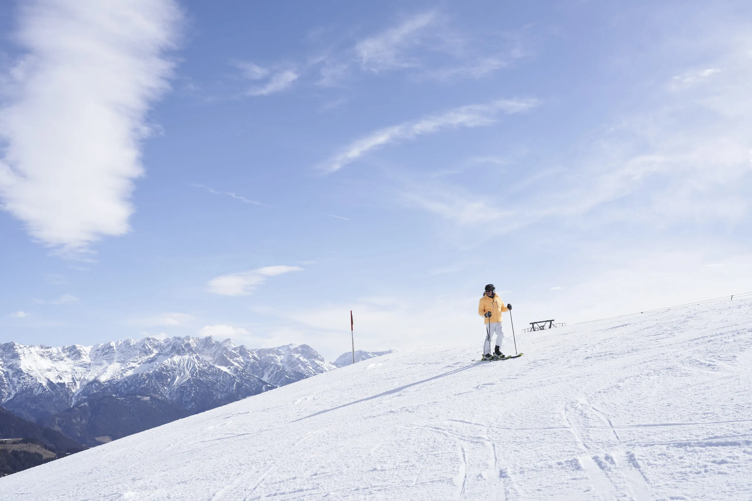 Skifahrer auf einer verschneiten Piste in Leogang