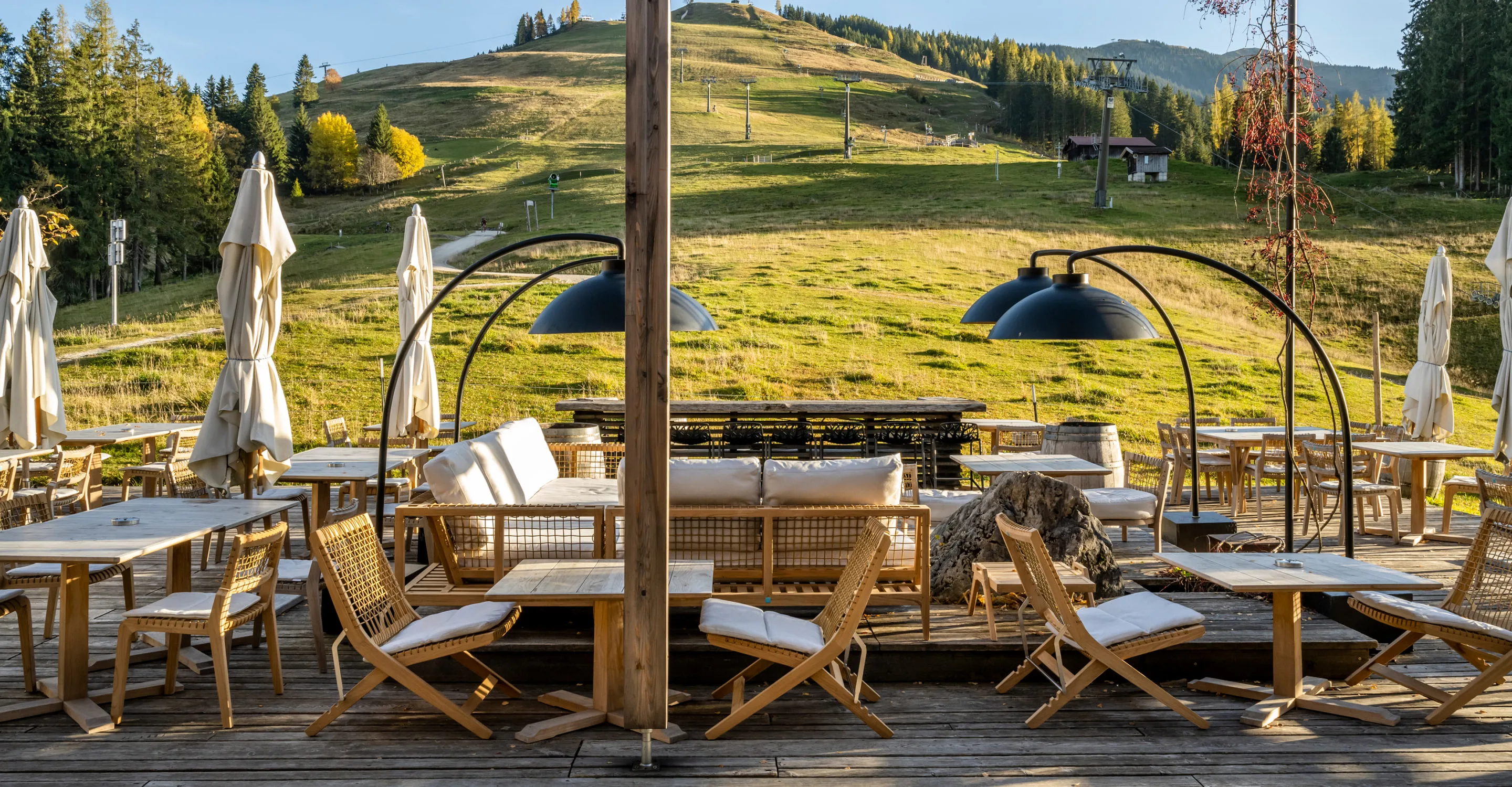 Terrasse mit Holzstühlen und Blick auf die Hügel