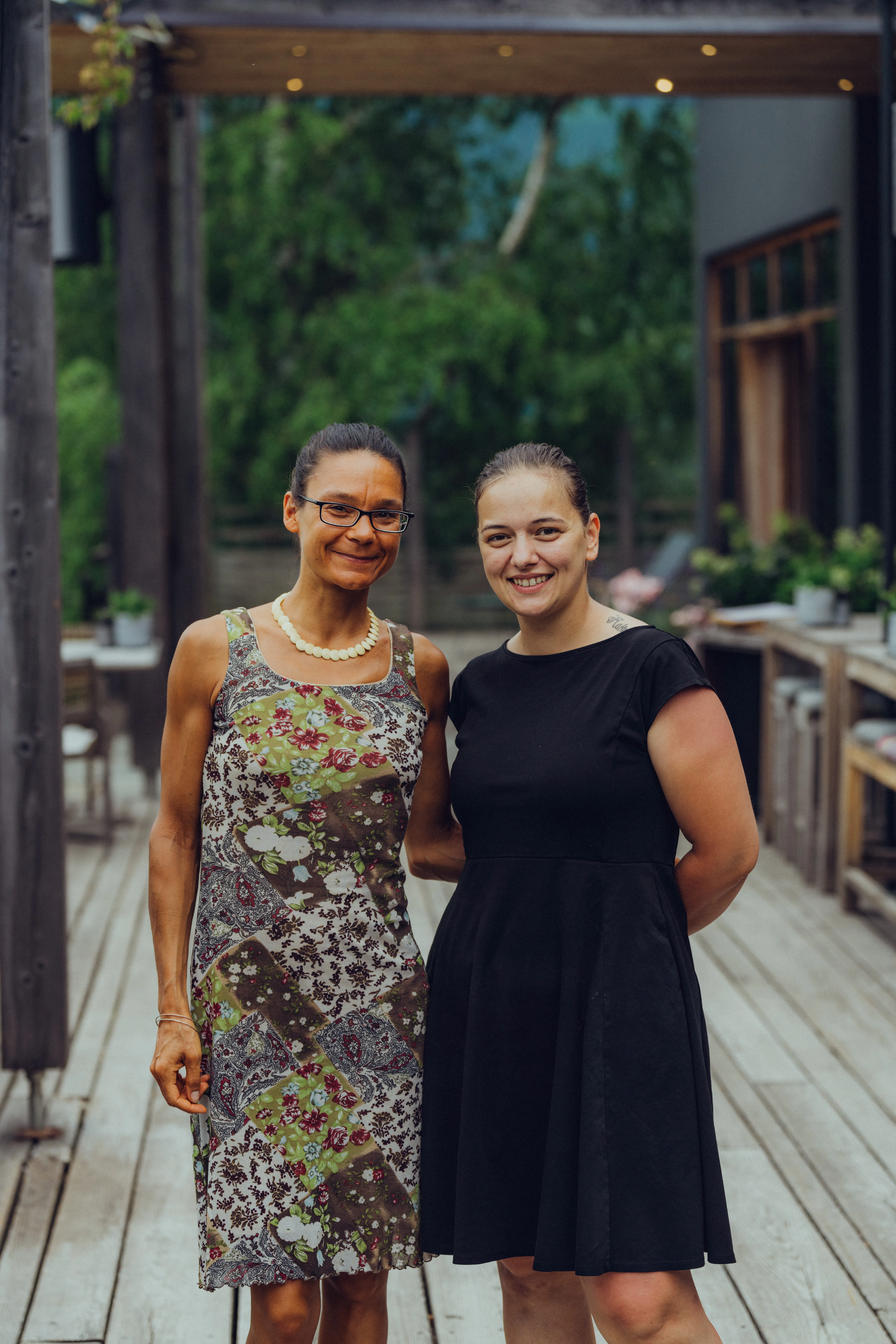 Zwei Frauen stehen auf einer Holzterrasse